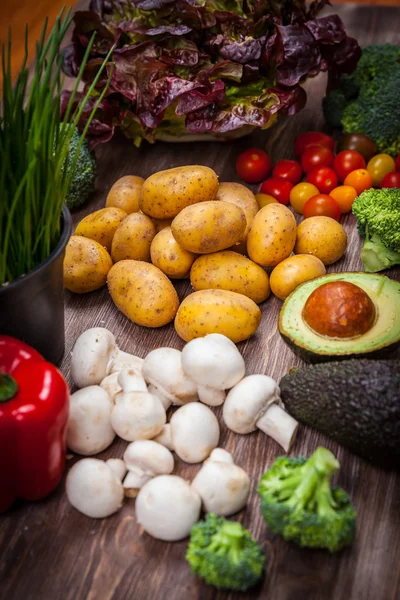 Vegetais crus sortidos em fundo de madeira — Fotografia de Stock