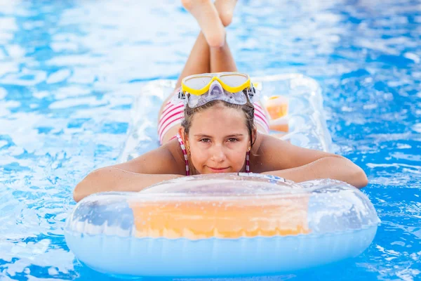 Menina bonito relaxante na piscina — Fotografia de Stock