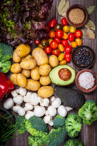 Vegetais crus sortidos em fundo de madeira — Fotografia de Stock