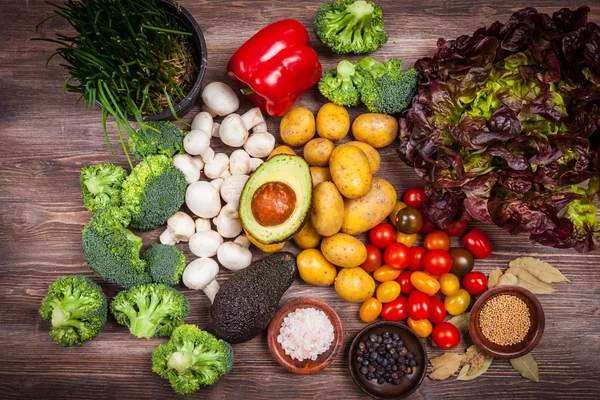 Vegetais crus sortidos em fundo de madeira — Fotografia de Stock