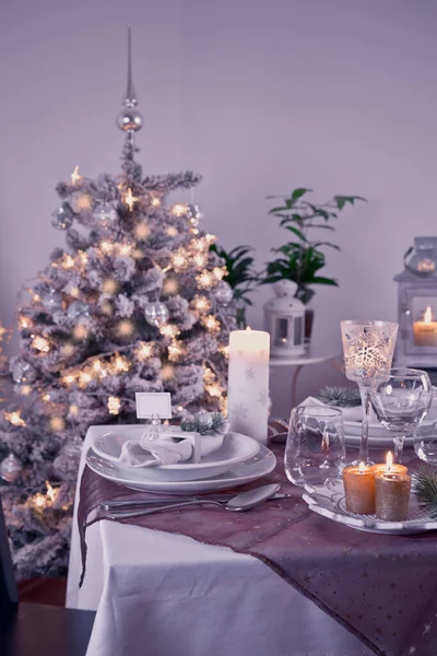 お祝いのクリスマスと新年の休日のテーブル設定 家での祝祭テーブルとともにクリスマスツリーで紫色のトーン — ストック写真