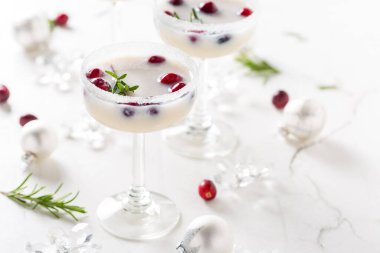 Beyaz Noel margarita pançı, kızılcık ve mermer arka planda biberiye.