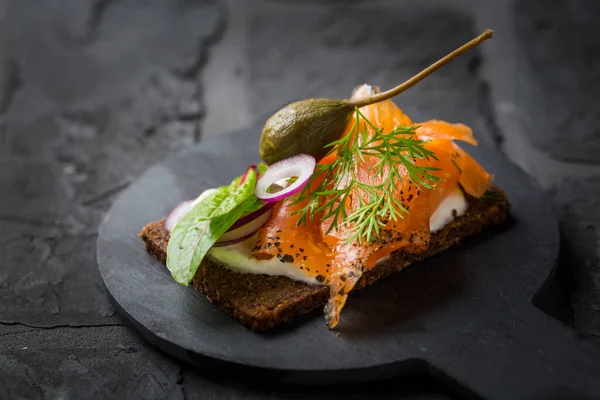 Σολομός Ανοιχτός Ψωμί Pumpernickel Λαχανικά Βότανα Και Μαλακό Τυρί — Φωτογραφία Αρχείου