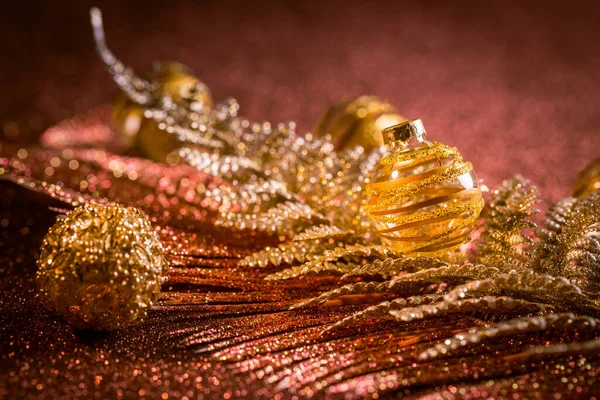 赤と金色の色調でキラキラした背景を持つクリスマスボールや装飾品 選択的焦点 — ストック写真