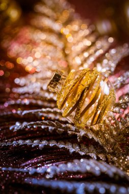 Mor ve altın tonlarda parıltılı arkaplanlı Noel süsleri ve toplar. Seçici odak.