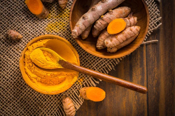 姜黄根和粉 姜黄粉 作为木制背景的烹调配料 — 图库照片