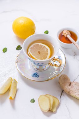 Beyaz arka planda limonlu, zencefilli ve ballı çay