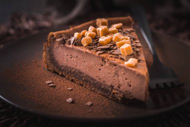 Koyu arkaplanda tuzlu karamel ile çikolatalı cheesecake