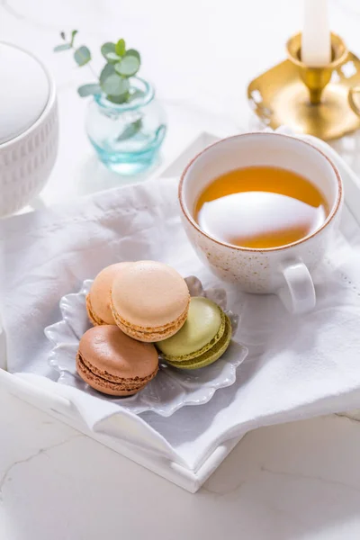 Macarons dessert and cup of tea on white table