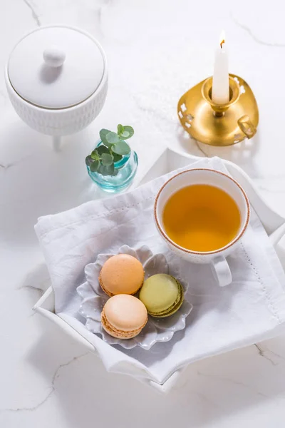 Macarons dessert and cup of tea on white table