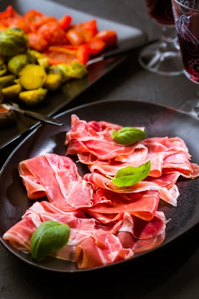 黒を背景に赤ワインのガラスと異なる前菜とProsciutto ロースト野菜 健康的なスナック以上 — ストック写真