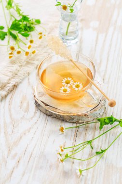 Bir fincan papatya çayı ahşap mutfak masasında.. 