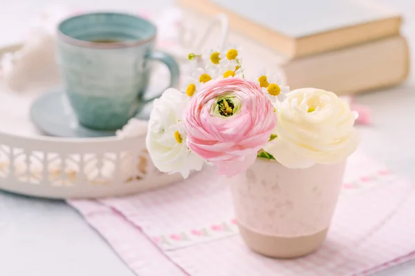 キッチンテーブルの上に背景に茶の本のカップと新鮮なカットの花束の美しい柔らかい開花 — ストック写真