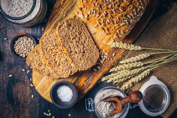 Zelfgemaakte Volkorenspelt Brood Met Zonnebloempitten Bakingrediënten Houten Ondergrond — Stockfoto