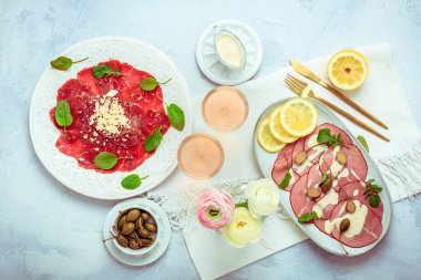 Aperatifler - Vitello tonnato ve Carpaccio bifteği ile iki bardak gül şarabı.