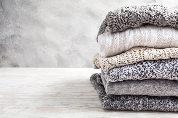 一堆堆舒适的针织毛衣和木制背景的套头衫 秋季和冬季概念 — 图库照片