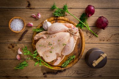 Çiğ tavuk soğanlı, sarımsaklı ve baharatlı ahşap masada pişirmeye hazır.