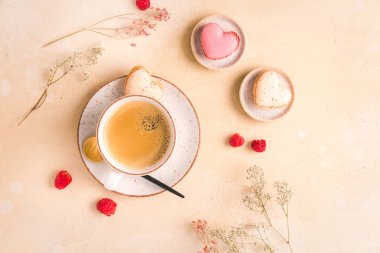 Mutfak masasında tatlı badem kurabiyesi olan bir fincan kahve.