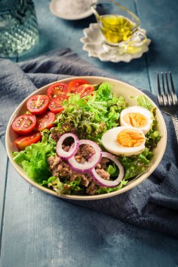 Ton balığı, yumurta, domates ve soğanlı salata kasesi.