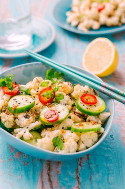 Kızarmış karnabahar, salatalık, soğan ve biberli Asya salatası.