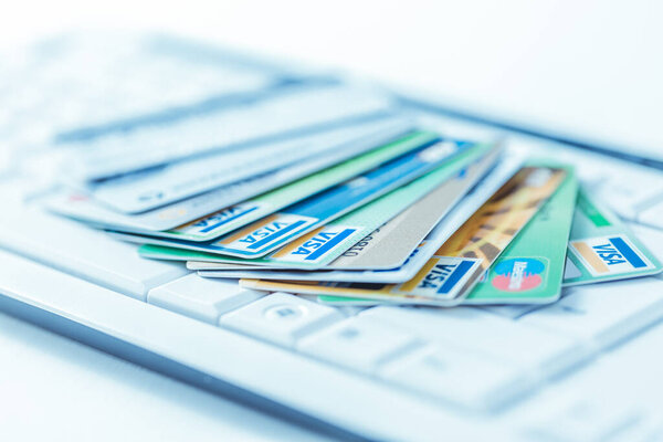 Group of credit cards on computer keyboard with VISA and MasterCard brand logos