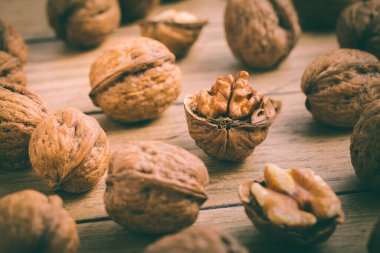 Küçük fındık kıracağı olan organik cevizler ahşap arka planda pişirme malzemeleri olarak kullanılıyor.