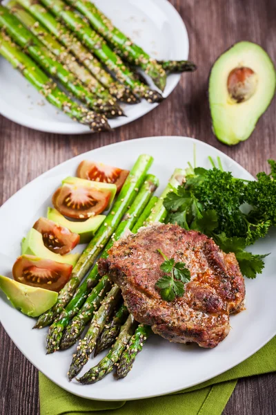 Glasierter grüner Spargel mit gegrilltem Schweinekotelett — Stockfoto