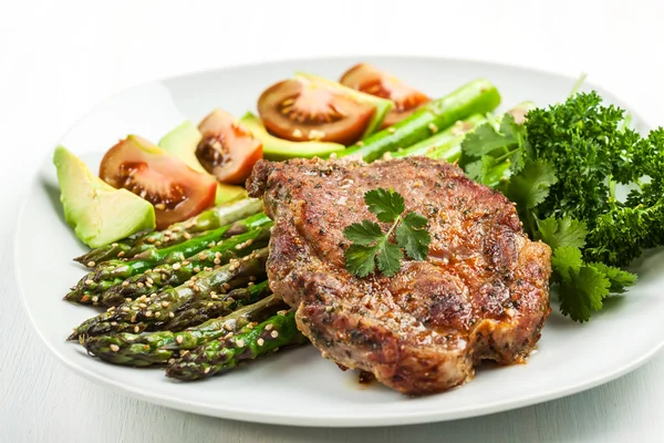 Glazed green asparagus with grilled pork chop — Stock Photo, Image