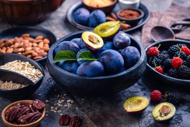 Freshly picked berries and plums with healthy baking ingredients