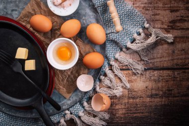 Çırpılmış yumurta ya da omlet hazırlıyorum. Mutfak aletleri ve demir tava.