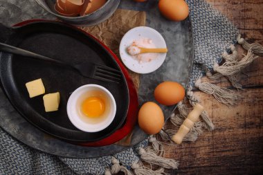 Çırpılmış yumurta ya da omlet hazırlıyorum. Mutfak aletleri ve demir tava.