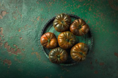 Yeşil bir arka planda büyük siyah domates.