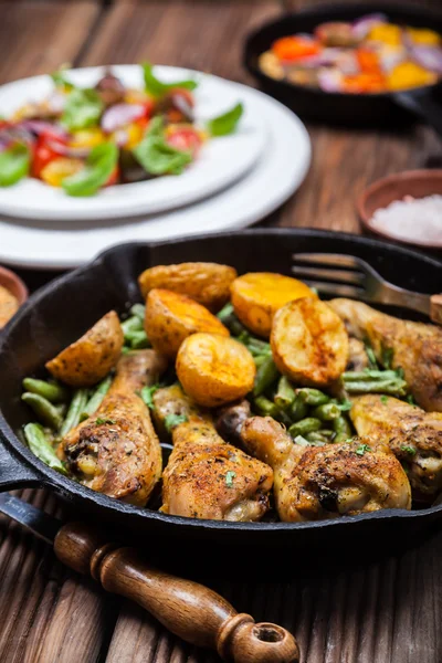 Kycklingklubbor i stekpanna med potatis och sallad — Stockfoto