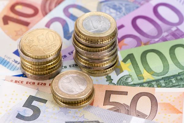 Euro-Banknoten und gestapelte Münzen — Stockfoto