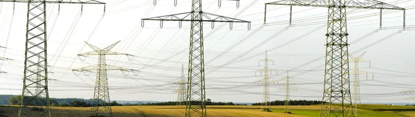 Panorama view to many electric power poles — Stock Photo, Image