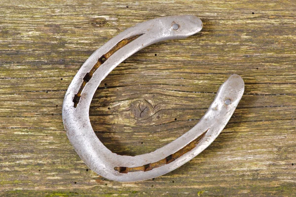 Sapato de cavalo na prancha de madeira — Fotografia de Stock