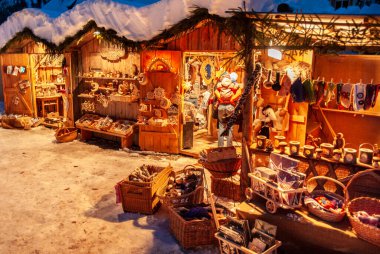 Karlı Noel Pazarı, yanan dükkanlar ahşap kulübelerde hediyeler ve el yapımı dekorasyonlar..