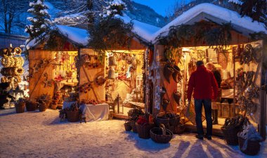 Karlı Noel Pazarı, yanan dükkanlar ahşap kulübelerde hediyeler ve el yapımı dekorasyonlar..