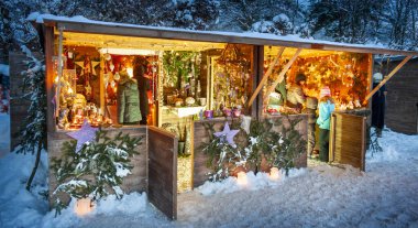 Karlı Noel Pazarı, yanan dükkanlar ahşap kulübelerde hediyeler ve el yapımı dekorasyonlar..