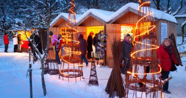 Karlı Noel Pazarı, yanan dükkanlar ahşap kulübelerde hediyeler ve el yapımı dekorasyonlar..