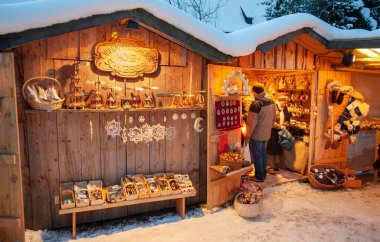 Karlı Noel Pazarı, yanan dükkanlar ahşap kulübelerde hediyeler ve el yapımı dekorasyonlar..