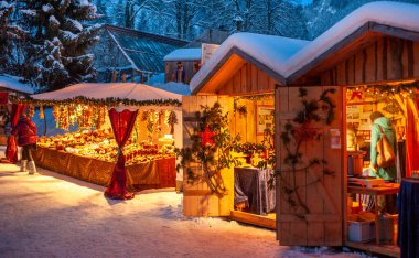 Karlı Noel Pazarı, yanan dükkanlar ahşap kulübelerde hediyeler ve el yapımı dekorasyonlar..