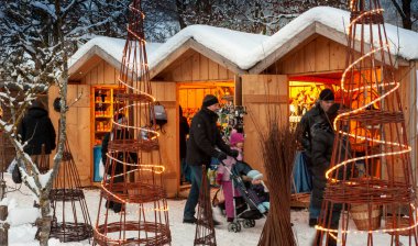 Karlı Noel Pazarı, yanan dükkanlar ahşap kulübelerde hediyeler ve el yapımı dekorasyonlar..