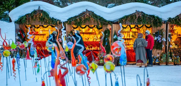 ギフトや手作りの装飾が施された木製の小屋でライトアップされたお店で雪のクリスマスマーケット — ストック写真