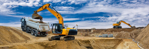 excavator working on construction site with dramatic sky