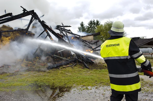 Brandweerman blust een brand — Stockfoto