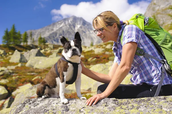 Hiking woman with dog in mountains — Stock Photo, Image
