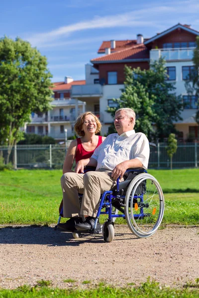 Man on wheelchair with young woman — Stock Photo, Image