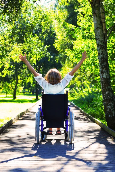 Kvinna på rullstolen med händerna upp — Stockfoto