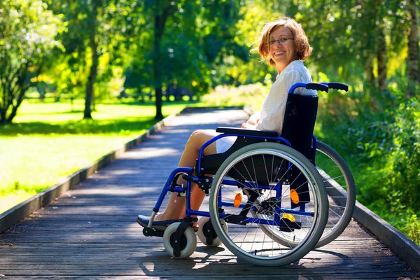 Ευτυχισμένος νεαρή ενήλικη γυναίκα σε αναπηρικό καροτσάκι στο πάρκο — Φωτογραφία Αρχείου